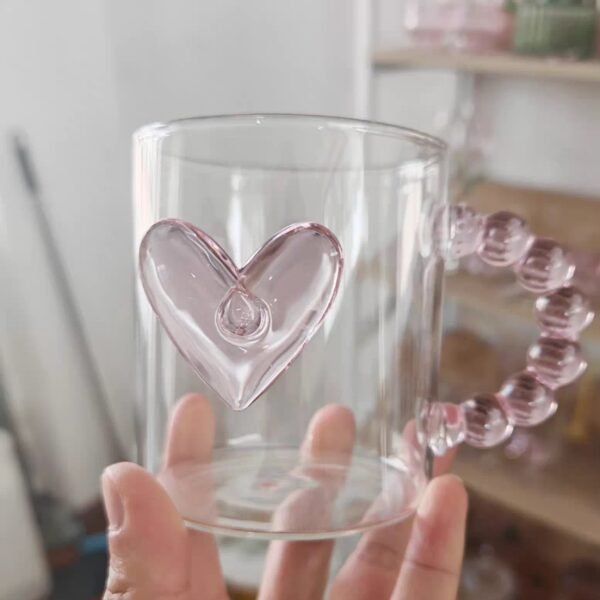 Heart Glass Mug 350ml held in hand showing pink heart design