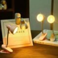 Mini clip book lights in pink and white lighting up books at night