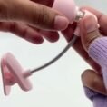 Hands holding the mini clip book light showing its flexible neck