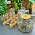 Glass jug set placed on a table with plants in a real home setting