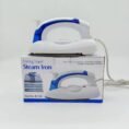 Folding travel steam iron sitting on its retail box