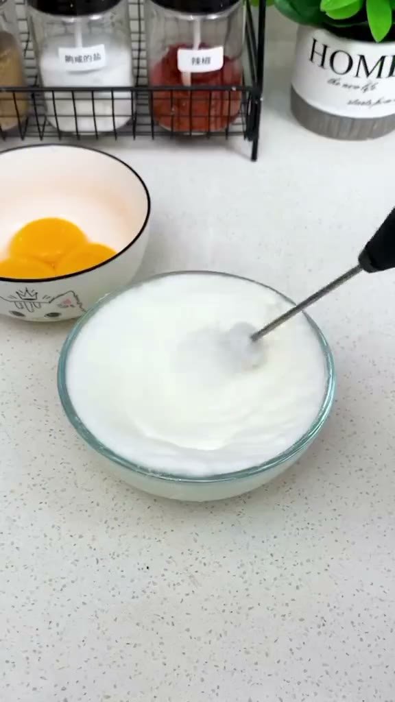 Electric egg beater whisking eggs in a bowl Electric egg beater whisking eggs in a bowl