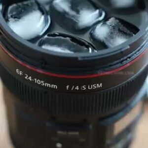 Camera lens travel mug filled with iced coffee close-up