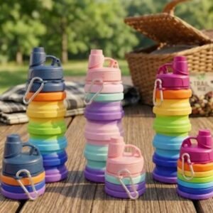 Rainbow collapsible silicone water bottles on a picnic table