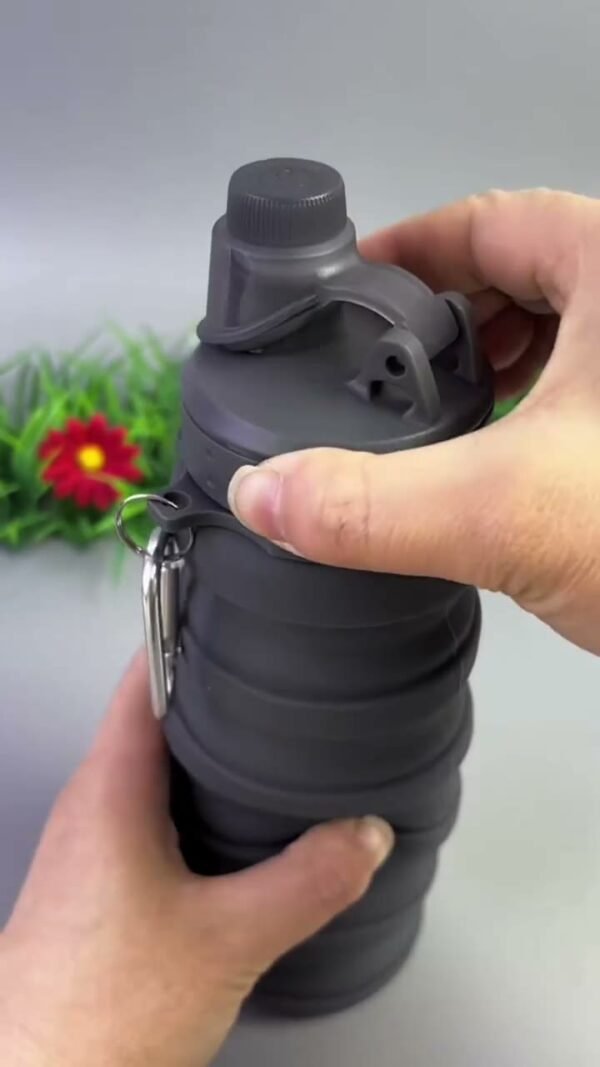 Black collapsible water bottle being opened by hand
