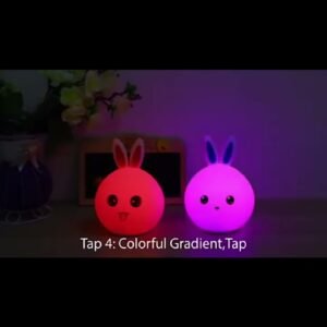 Two bunny silicone lamps glowing pink and purple on a shelf