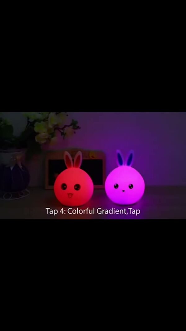 Two bunny silicone lamps glowing pink and purple on a shelf