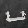 Self adhesive wall shelf with white human figure holders on tiles
