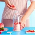 Portable juicer blender bottle filled with fresh strawberries