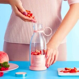 Portable juicer blender bottle filled with fresh strawberries